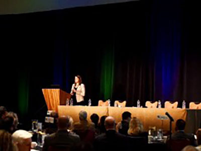 Gloria Sachdev giving a news update at an Employers' Forum of Indiana meeting